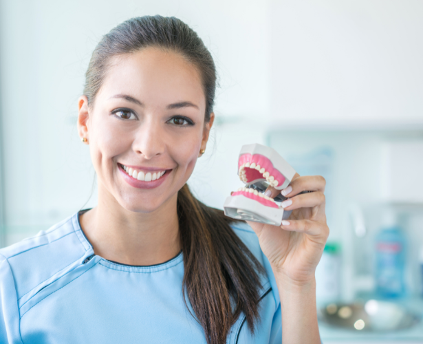 Dental assistant holding a denture model
