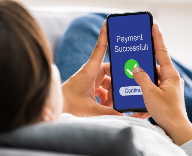 Person relaxing while confirming a successful payment on a smartphone
